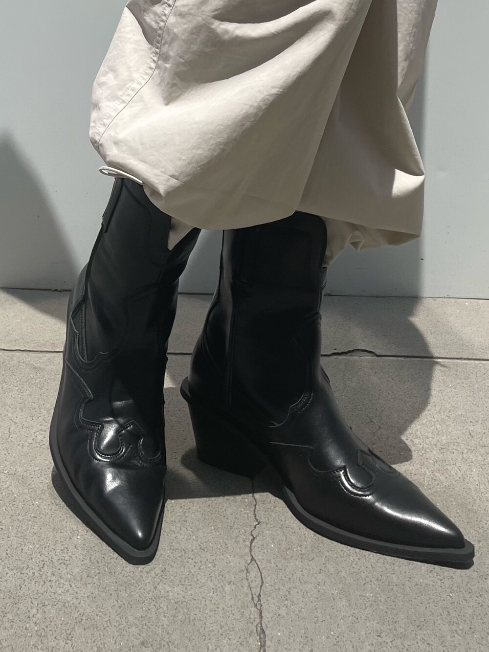 ホワイト系のカーゴパンツ、ブラック系のブーツ、ブラック系のベルトを着用したレディースの夏コーディネートの5枚目の写真