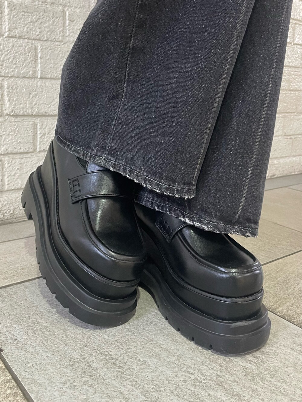 ブラック系のニット/セーター、ブラック系のハンドバッグ、ブラック系のデニムパンツを着用したレディースの冬コーディネートの9枚目の写真