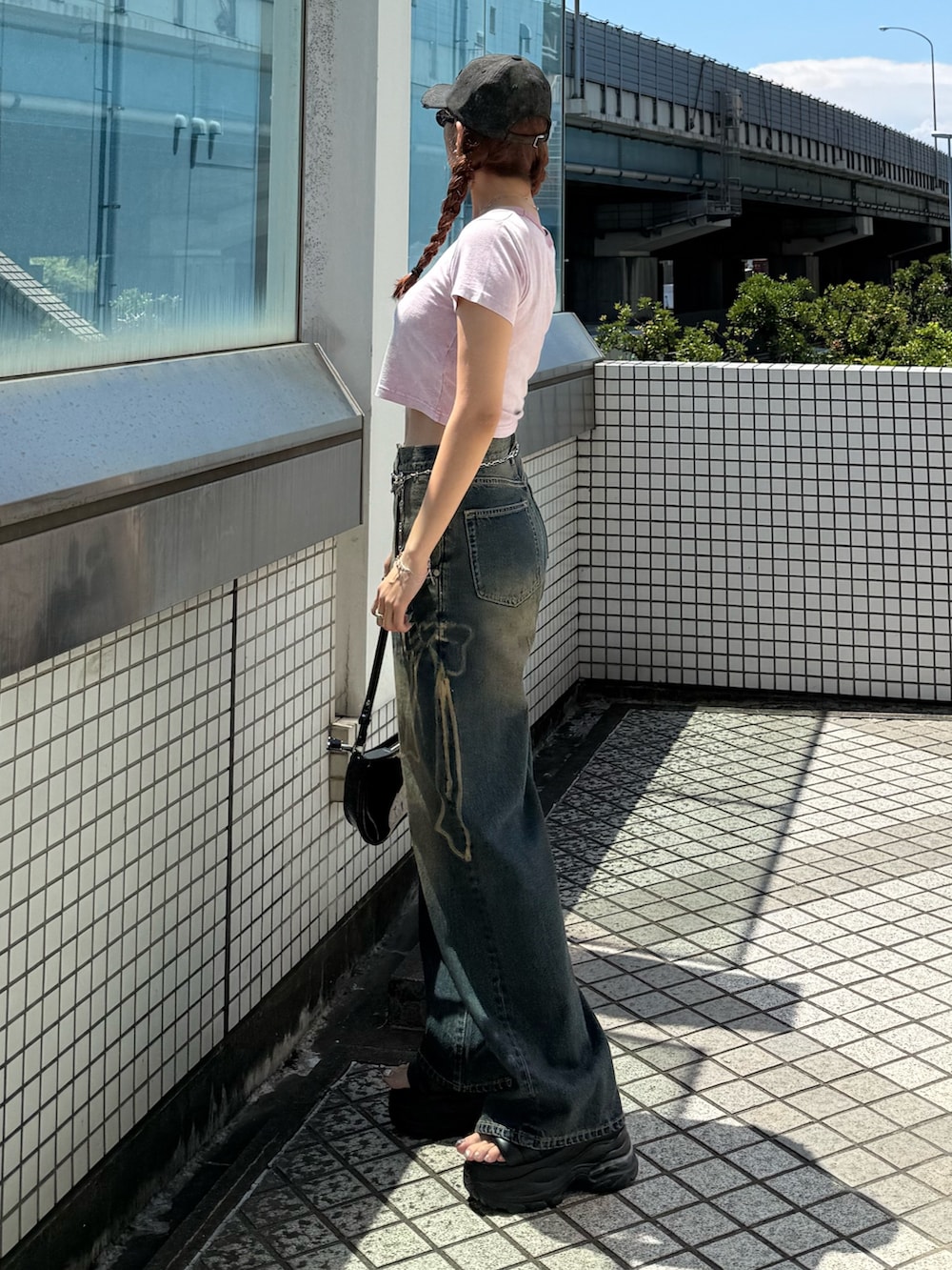 ピンク系のTシャツ/カットソー、ブルー系のデニムパンツ、ブラック系のショルダーバッグを着用したレディースの夏コーディネートの2枚目の写真