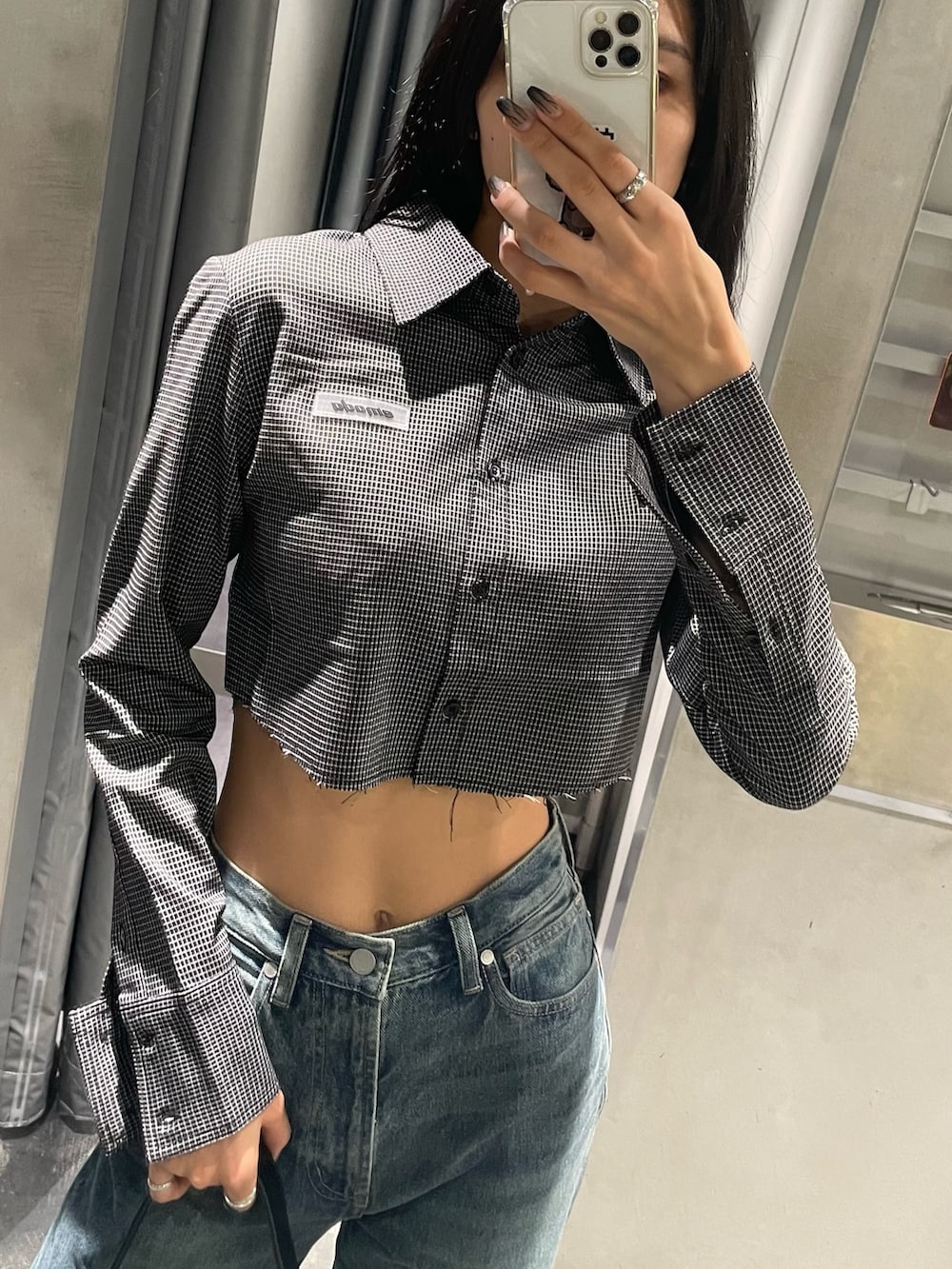 ブルー系のデニムパンツ、ブラック系のブーツ、ブラック系のハンドバッグを着用したレディースの秋コーディネートの2枚目の写真