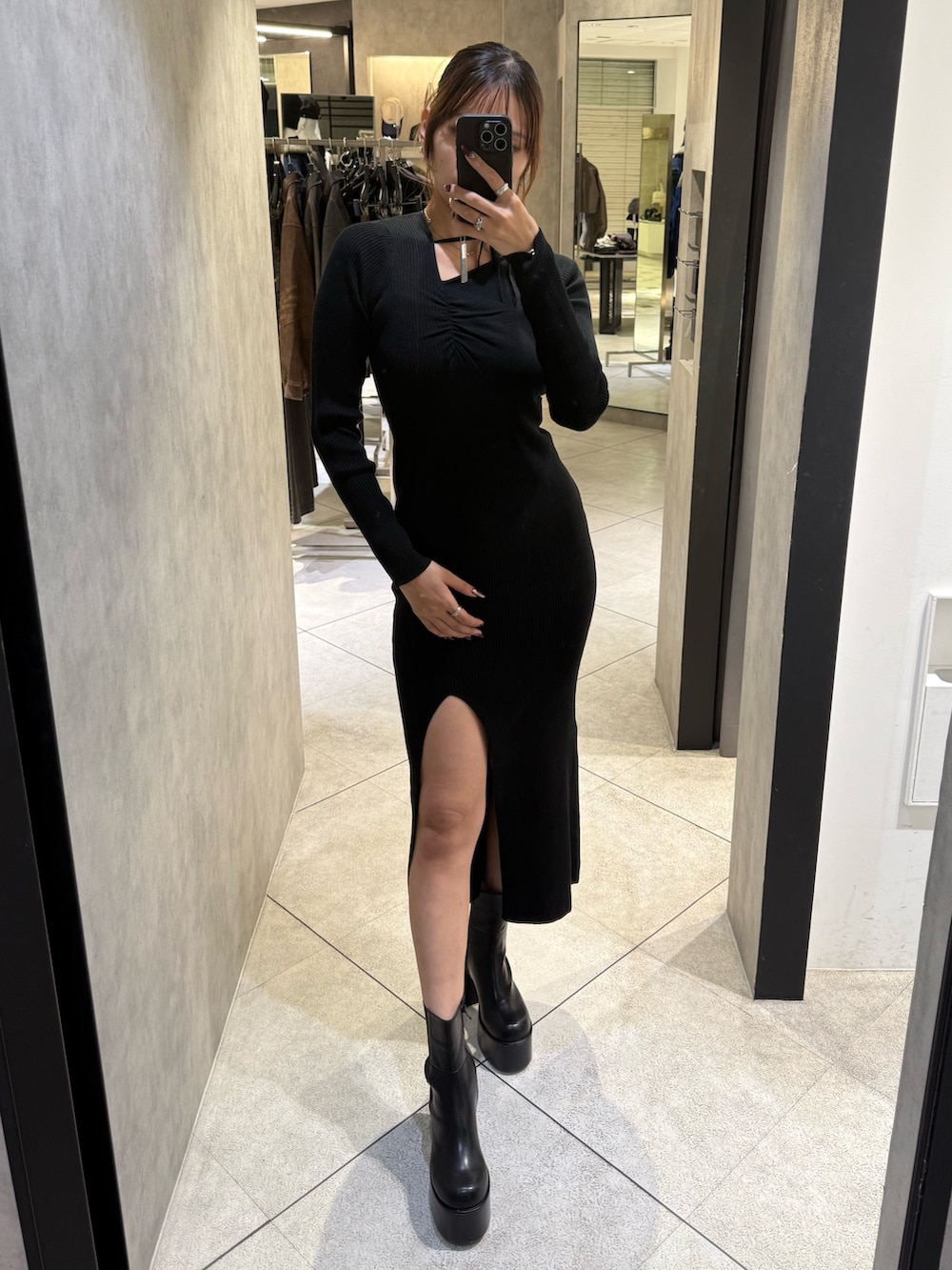 ブラック系のブルゾン、ブラック系のワンピース、ブラック系のブーツを着用したレディースの秋コーディネートの7枚目の写真