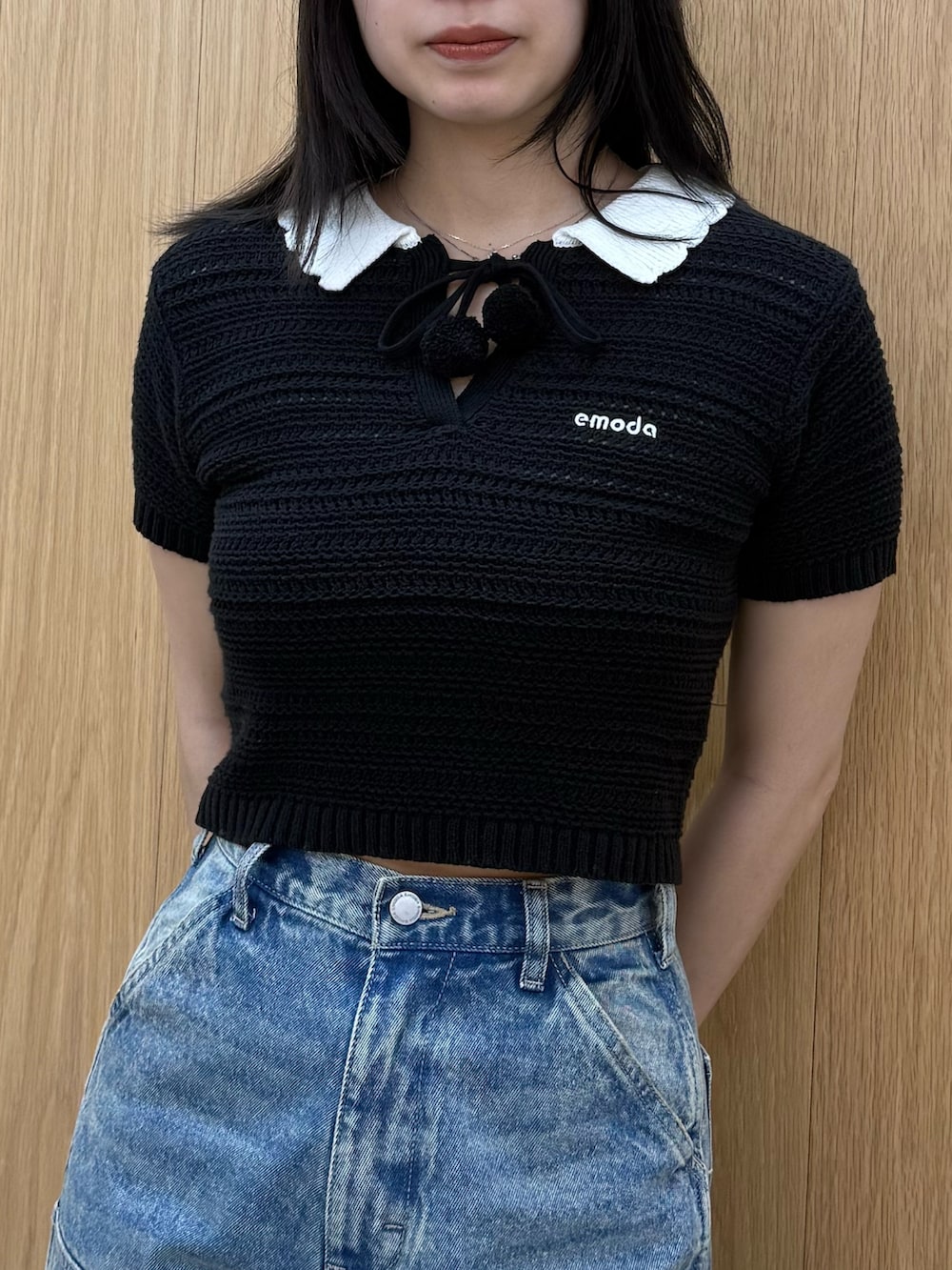 ブラック系のニット/セーター、ブルー系のデニムパンツ、ブラック系のサンダルを着用したレディースの春コーディネートの5枚目の写真