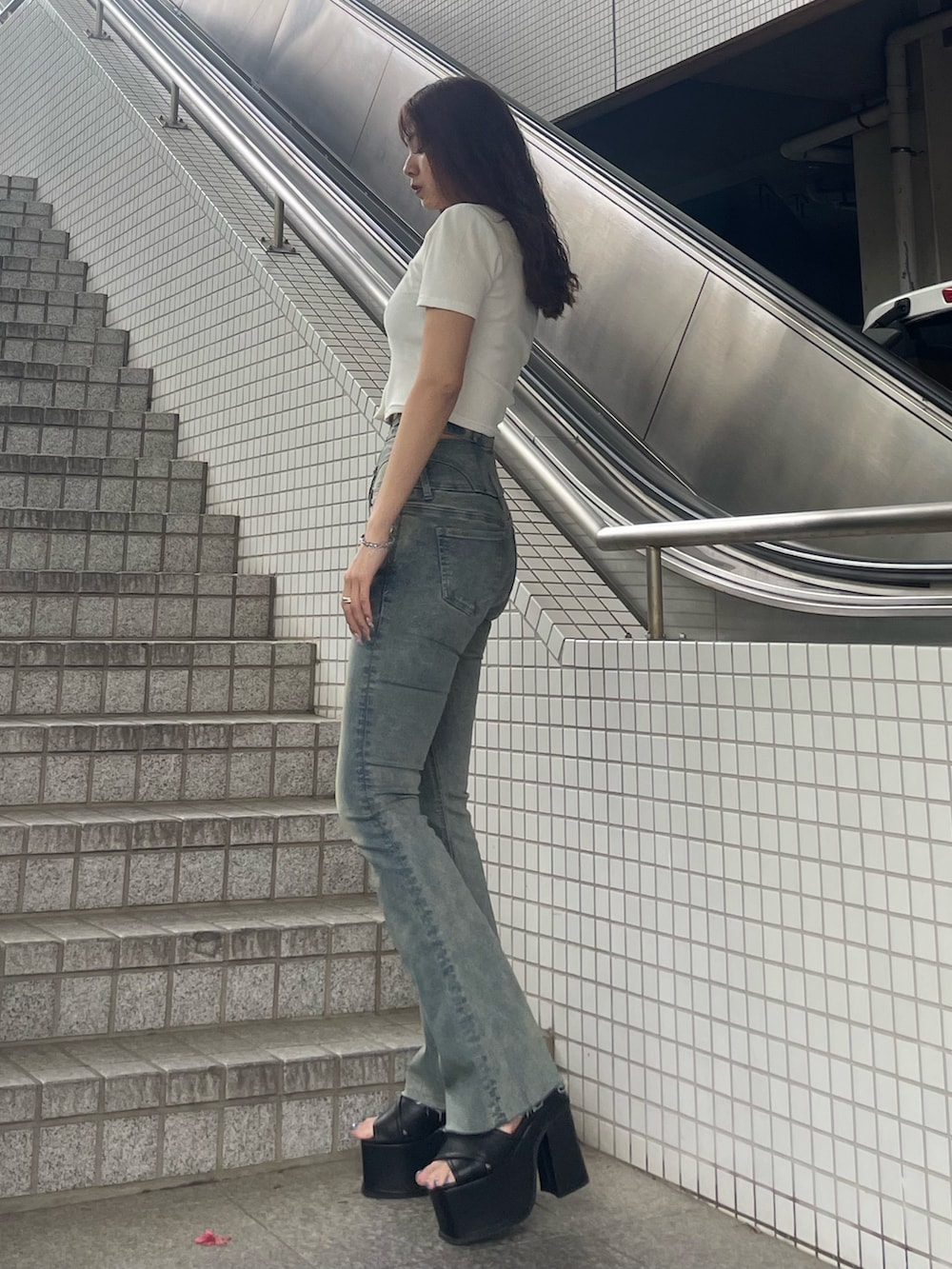 ホワイト系のTシャツ/カットソー、ブルー系のデニムパンツ、ブラック系のサンダルを着用したレディースの春コーディネートの2枚目の写真