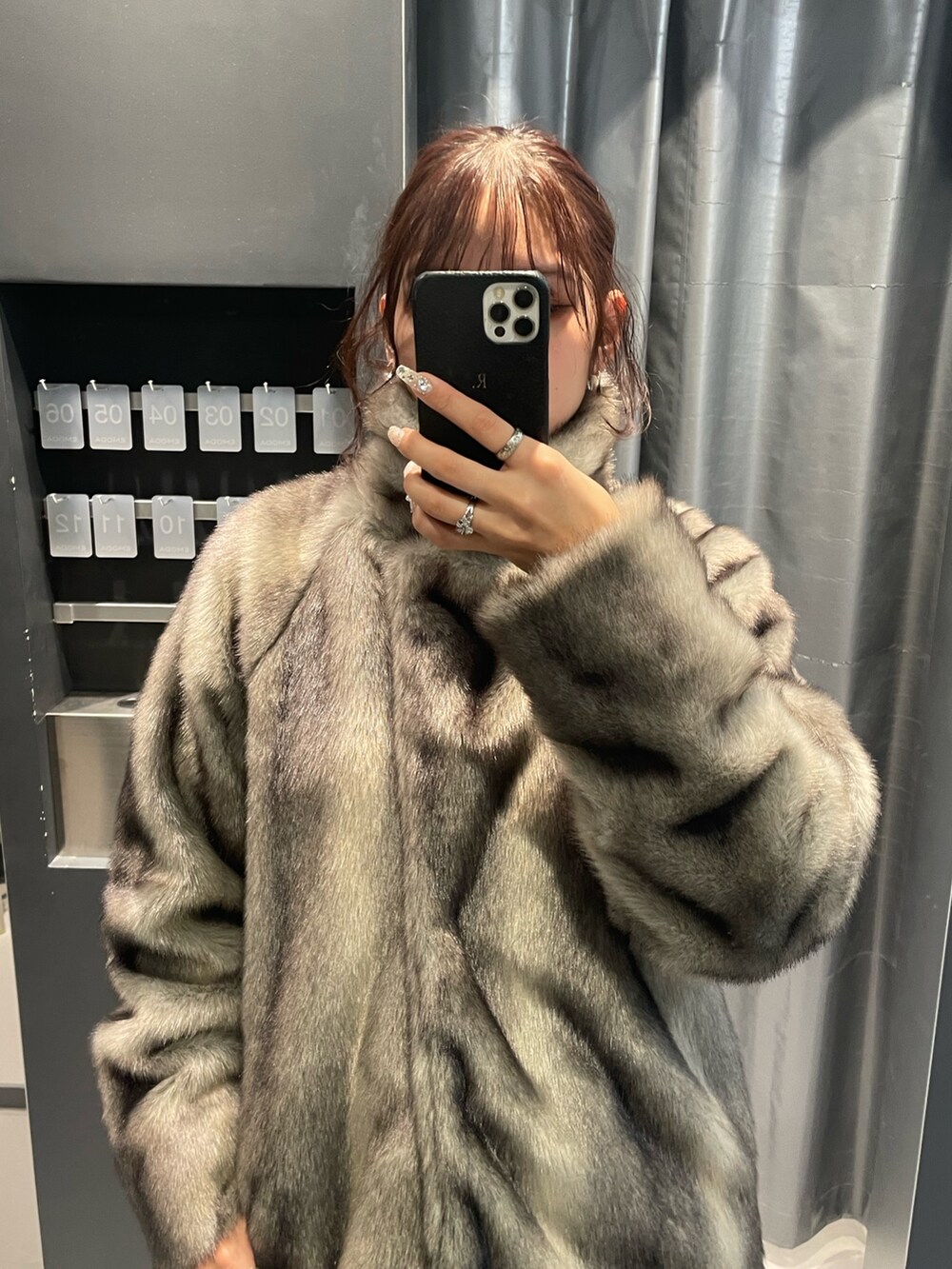 ホワイト系のニット/セーター、グレー系のその他アウター、ブラック系のスカートを着用したレディースの冬コーディネートの5枚目の写真