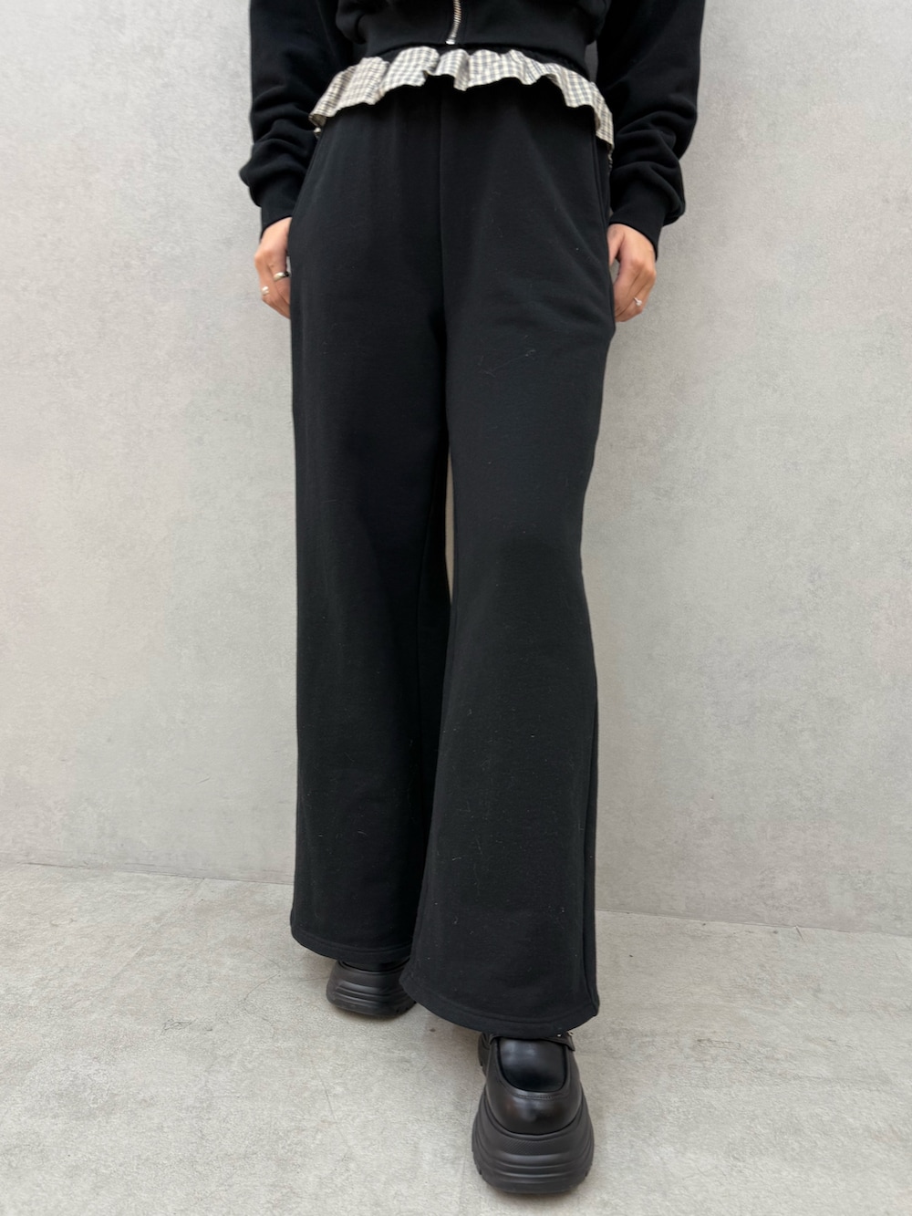 ブラック系のパーカー、ブラック系のスウェットパンツ、ブラック系のローファーを着用したレディースの冬コーディネートの5枚目の写真