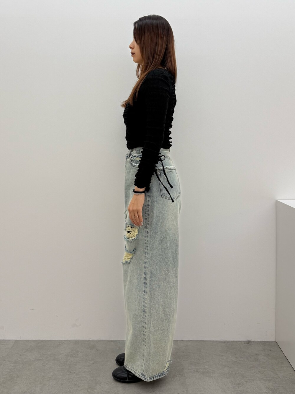 ブラック系のTシャツ/カットソー、ブルー系のデニムパンツ、ブラック系のスニーカーを着用したレディースの冬コーディネートの2枚目の写真