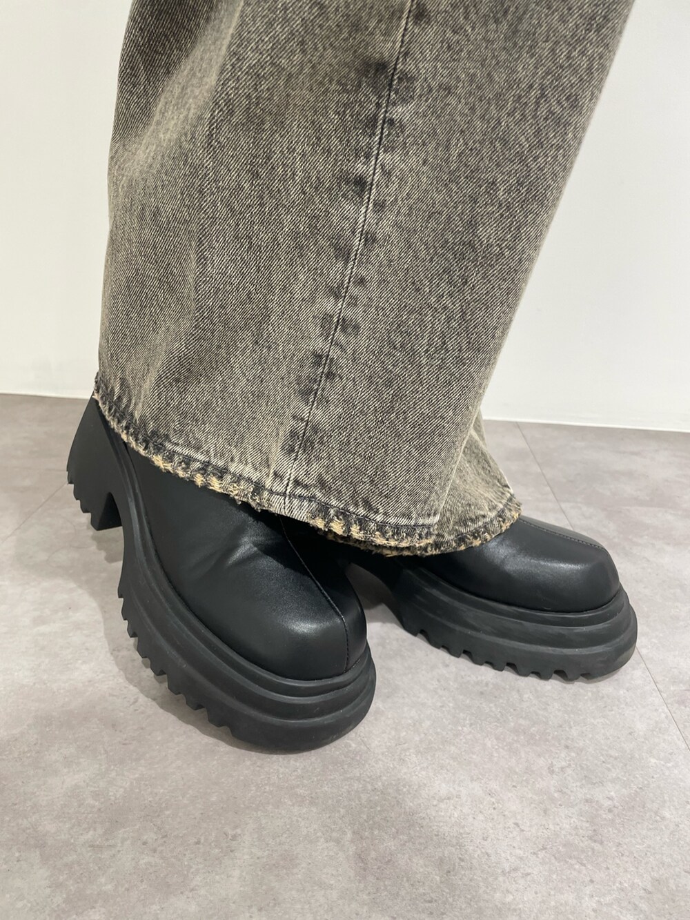 ブラック系のニット/セーター、グレー系のデニムパンツ、ブラック系のブーツを着用したレディースの春コーディネートの10枚目の写真