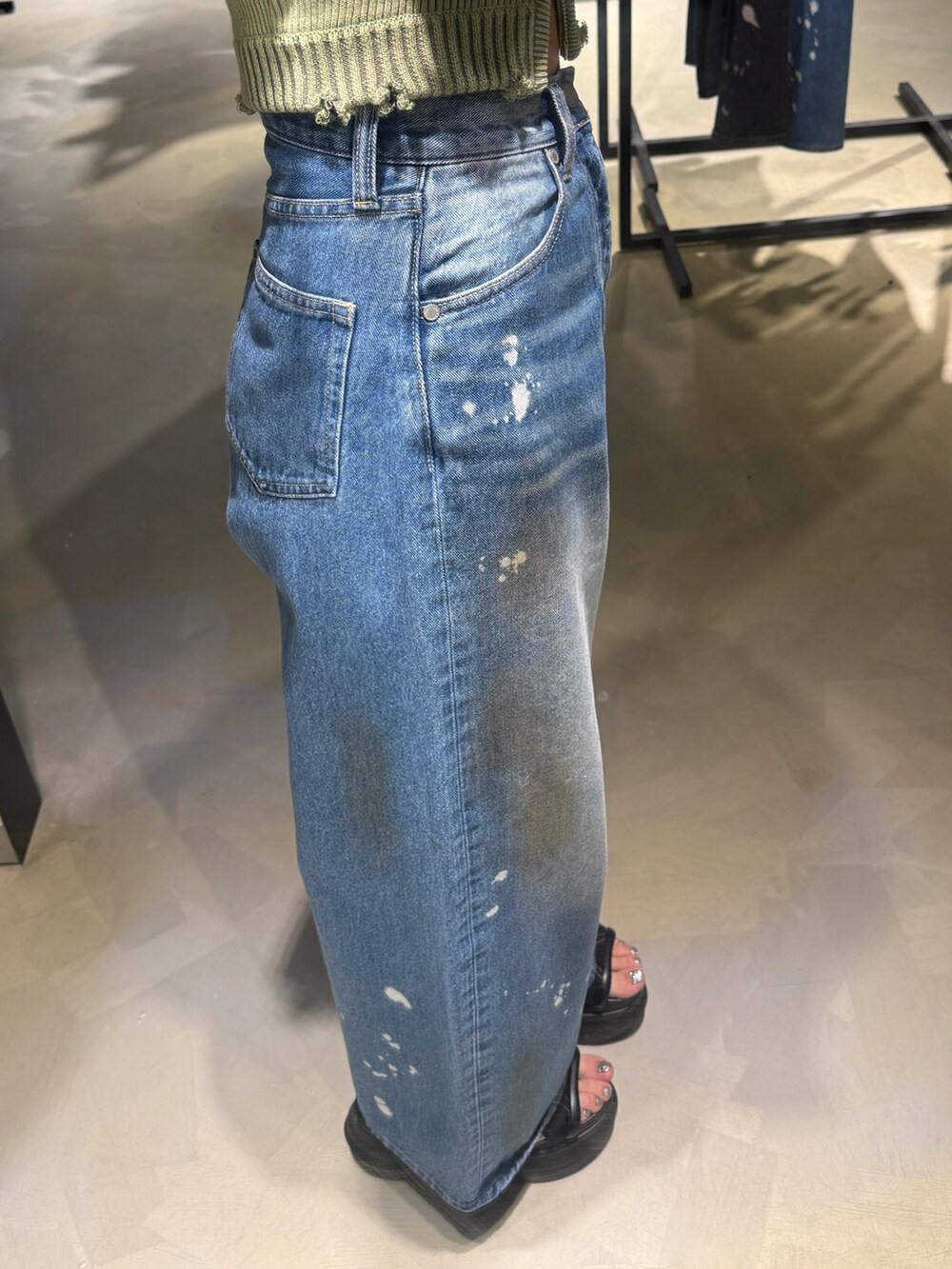 グリーン系のタンクトップ、ブルー系のデニムパンツ、ブラック系のハンドバッグを着用したレディースの夏コーディネートの7枚目の写真