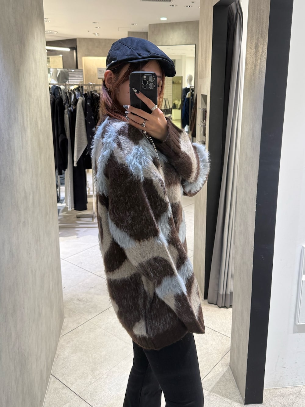 ブラウン系のニット/セーター、ブラック系のデニムパンツ、ブラック系のブーツを着用したレディースの秋コーディネートの5枚目の写真