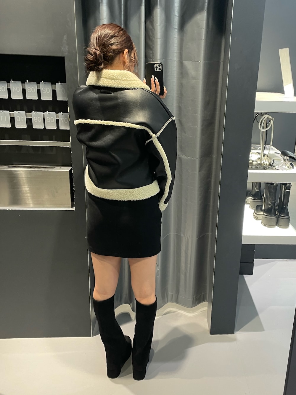 ホワイト系のニット/セーター、ブラック系のスカート、ブラック系のブルゾンを着用したレディースの冬コーディネートの3枚目の写真