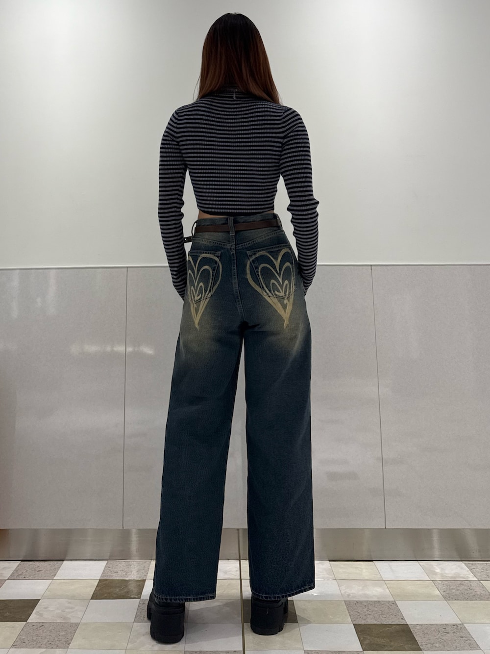 ブルー系のニット/セーター、ブルー系のデニムパンツ、ブラック系のブーツを着用したレディースの冬コーディネートの3枚目の写真