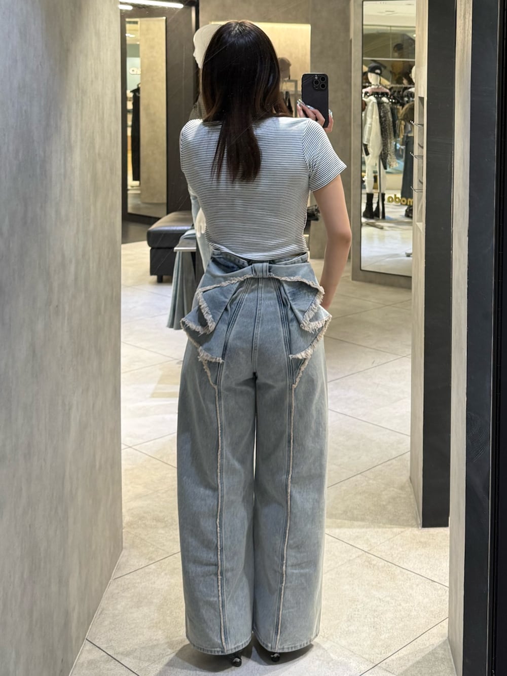 ホワイト系のTシャツ/カットソー、ブルー系のデニムパンツ、ブラック系のスニーカーを着用したレディースの春コーディネートの3枚目の写真