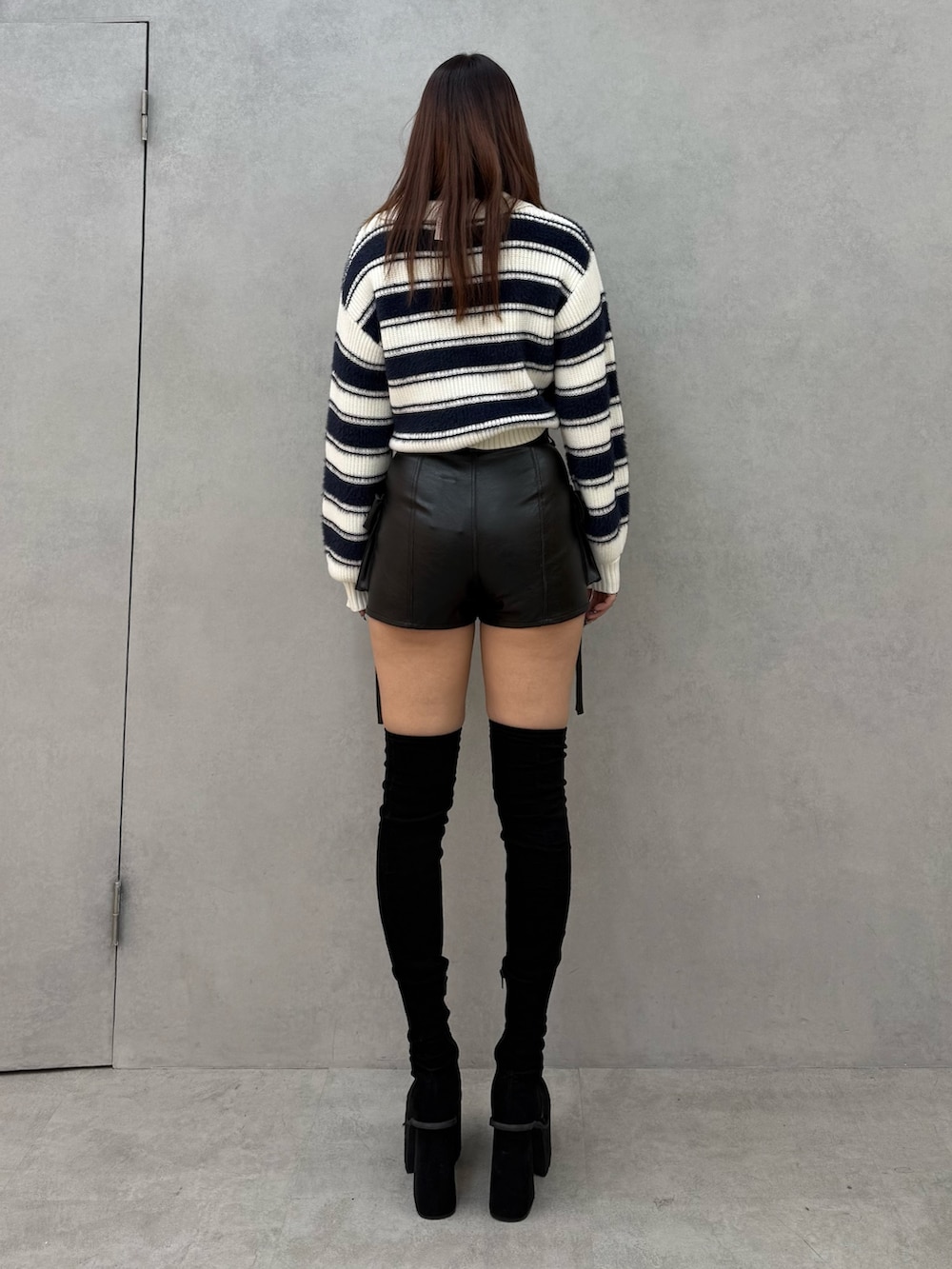 ブルー系のニット/セーター、ブラック系のその他パンツ、ブラック系のブーツを着用したレディースの冬コーディネートの3枚目の写真