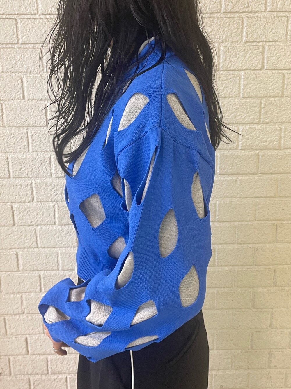 ブルー系のニット/セーター、ブラック系のスラックス、ブラック系のローファーを着用したレディースの冬コーディネートの5枚目の写真