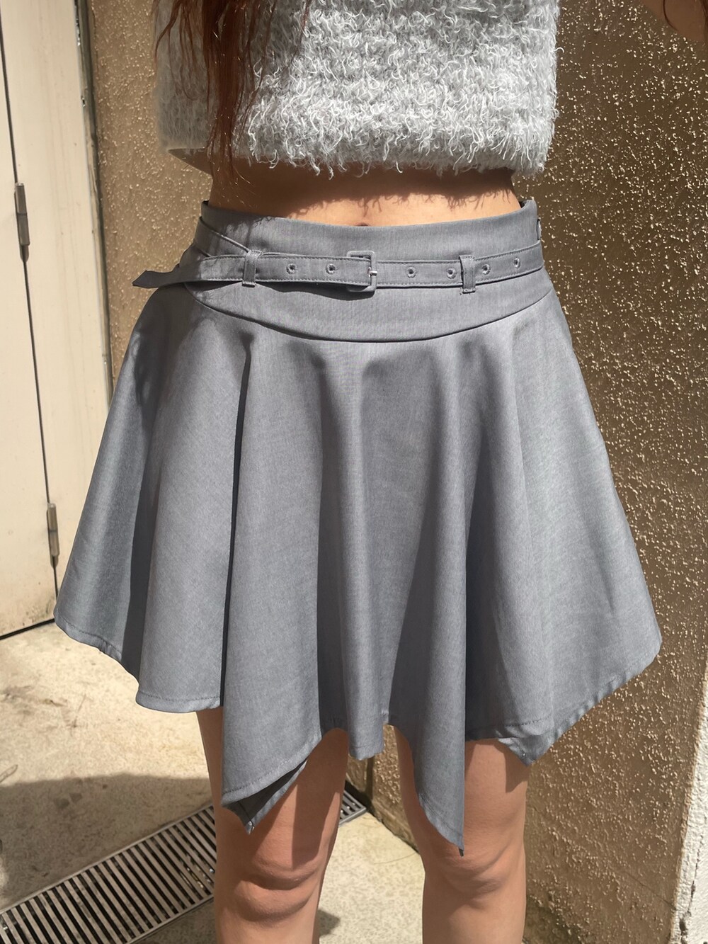 ホワイト系のTシャツ/カットソー、グレー系のニット/セーター、グレー系のスカートを着用したレディースの春コーディネートの5枚目の写真