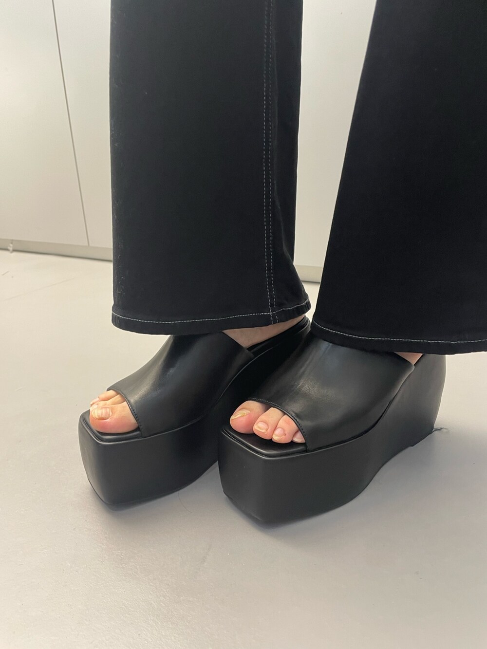 ブラック系のTシャツ/カットソー、グレー系のその他パンツ、ブラック系のサンダルを着用したレディースの春コーディネートの10枚目の写真