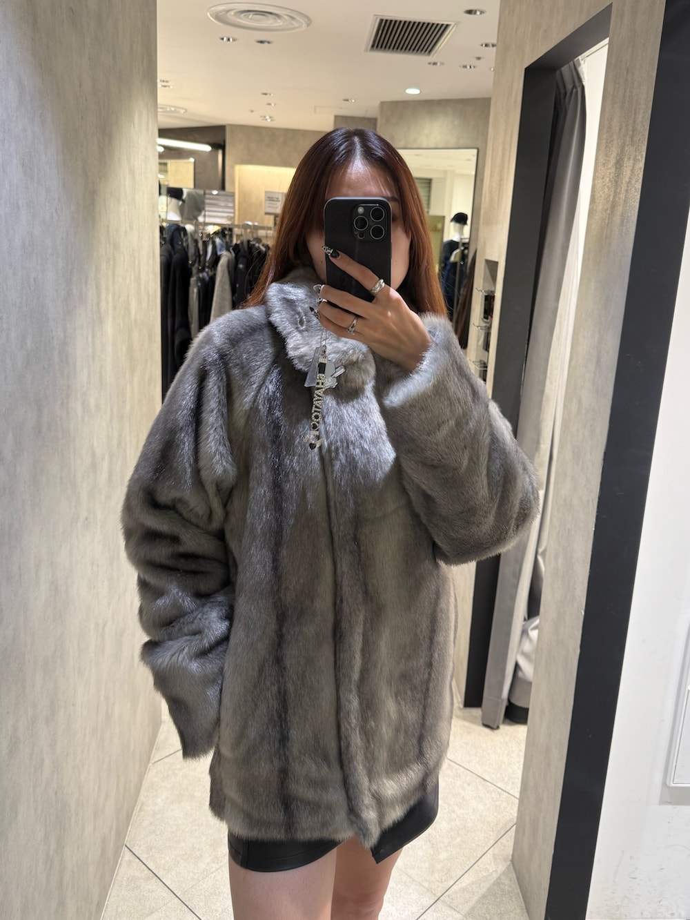 グレー系のその他アウター、ブラック系のスカート、ブラック系のブーツを着用したレディースの秋コーディネートの4枚目の写真