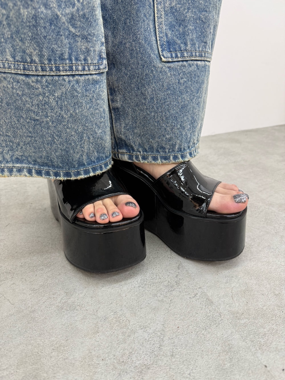ブラック系のサンダル、ブルー系のデニムパンツ、ホワイト系のTシャツ/カットソーを着用したレディースの春コーディネートの6枚目の写真
