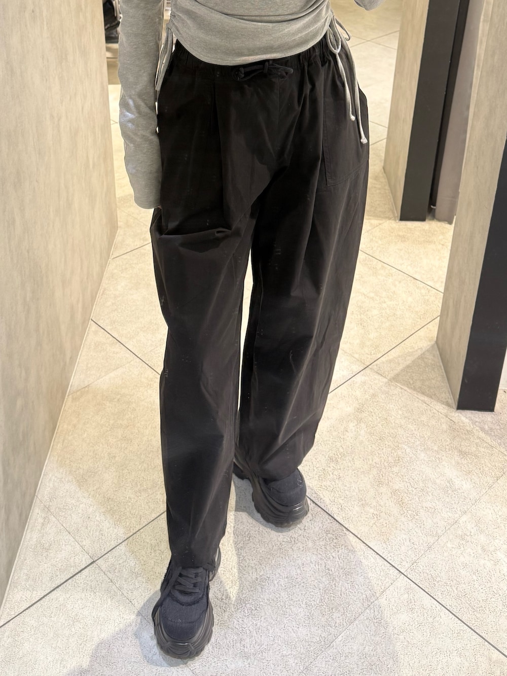 ブラック系のスニーカー、ブラック系のその他パンツ、ブルー系のニット/セーターを着用したレディースの春コーディネートの5枚目の写真