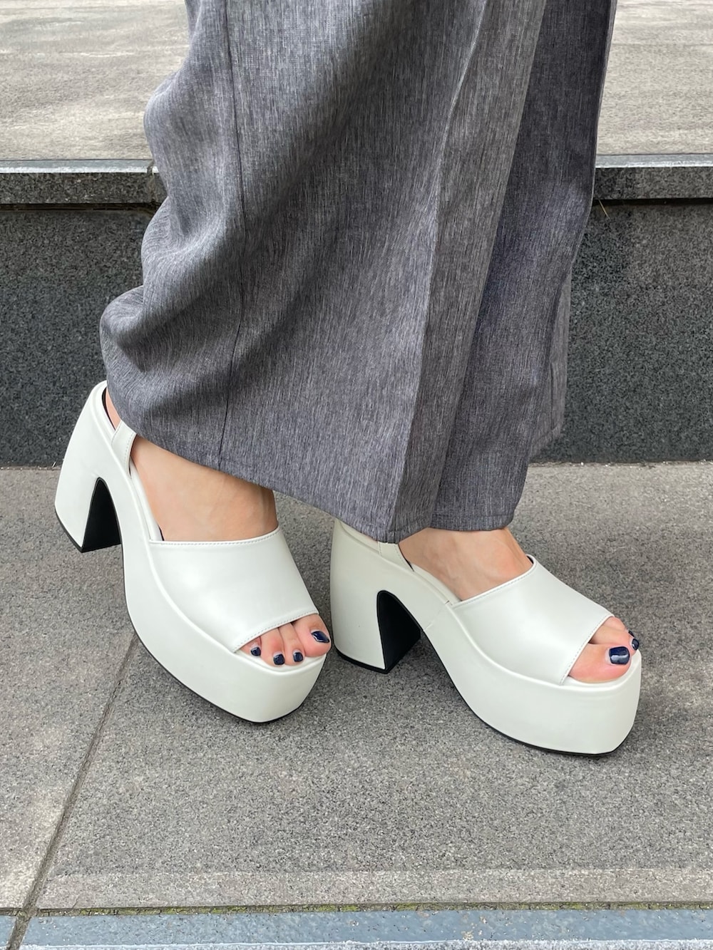 グレー系のサロペット/オーバーオール、ホワイト系のタンクトップ、ホワイト系のサンダルを着用したレディースの夏コーディネートの5枚目の写真