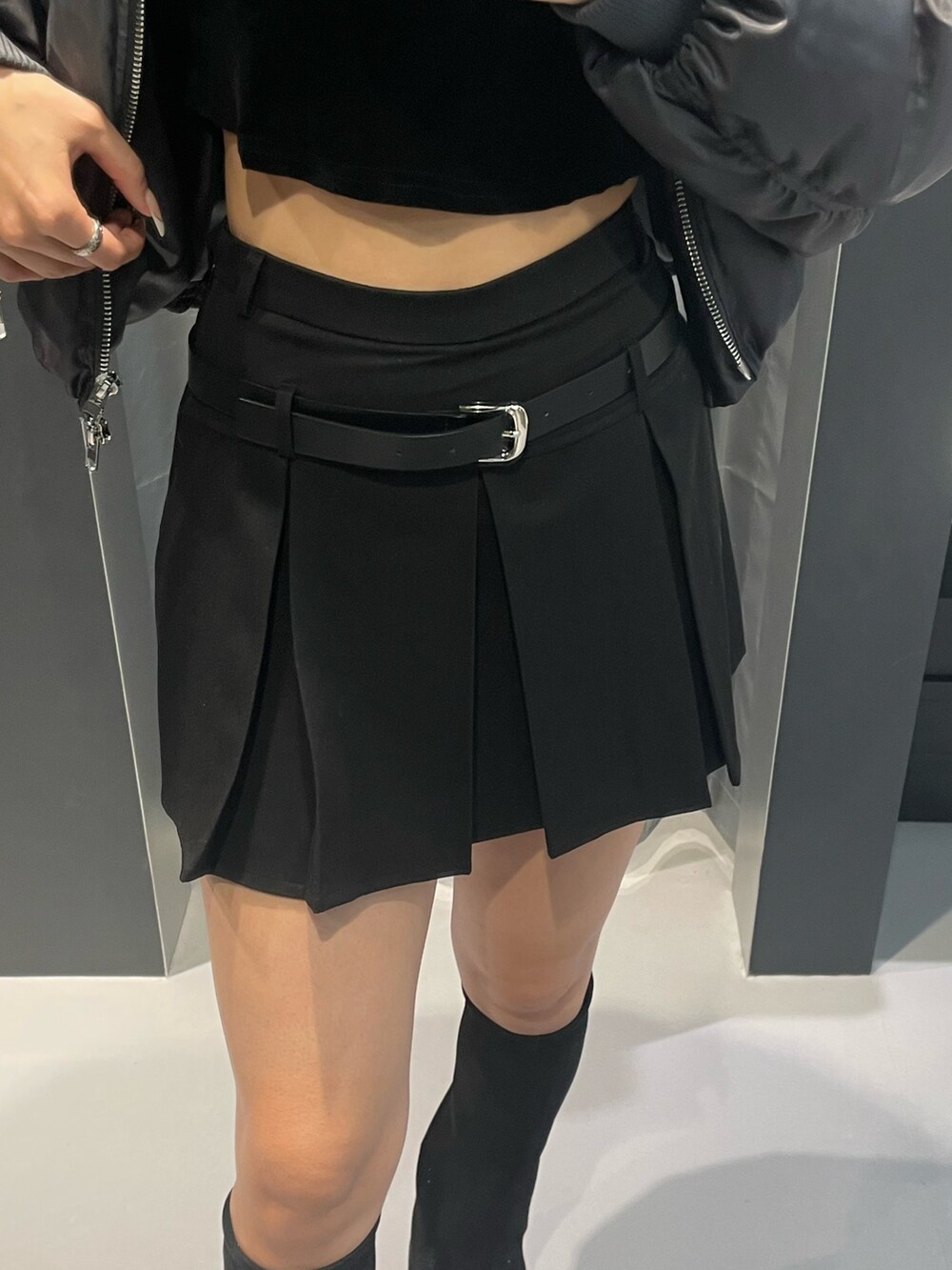 グレー系のブルゾン、ブラック系のTシャツ/カットソー、ブラック系のスカートを着用したレディースの冬コーディネートの6枚目の写真