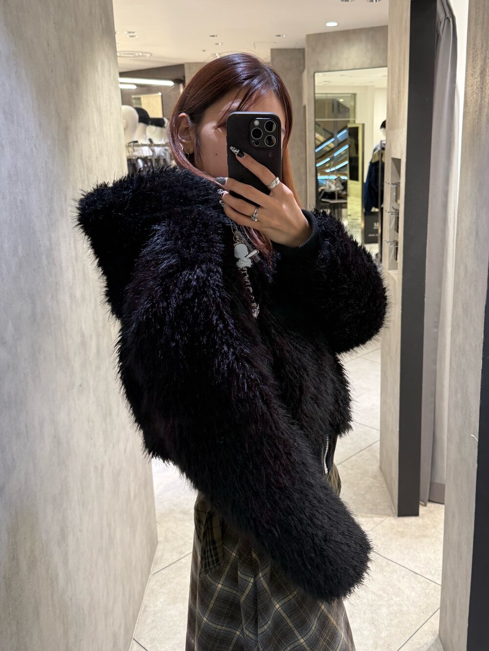 ブラック系のブルゾン、グリーン系のスカート、ブラック系のブーツを着用したレディースの秋コーディネートの5枚目の写真