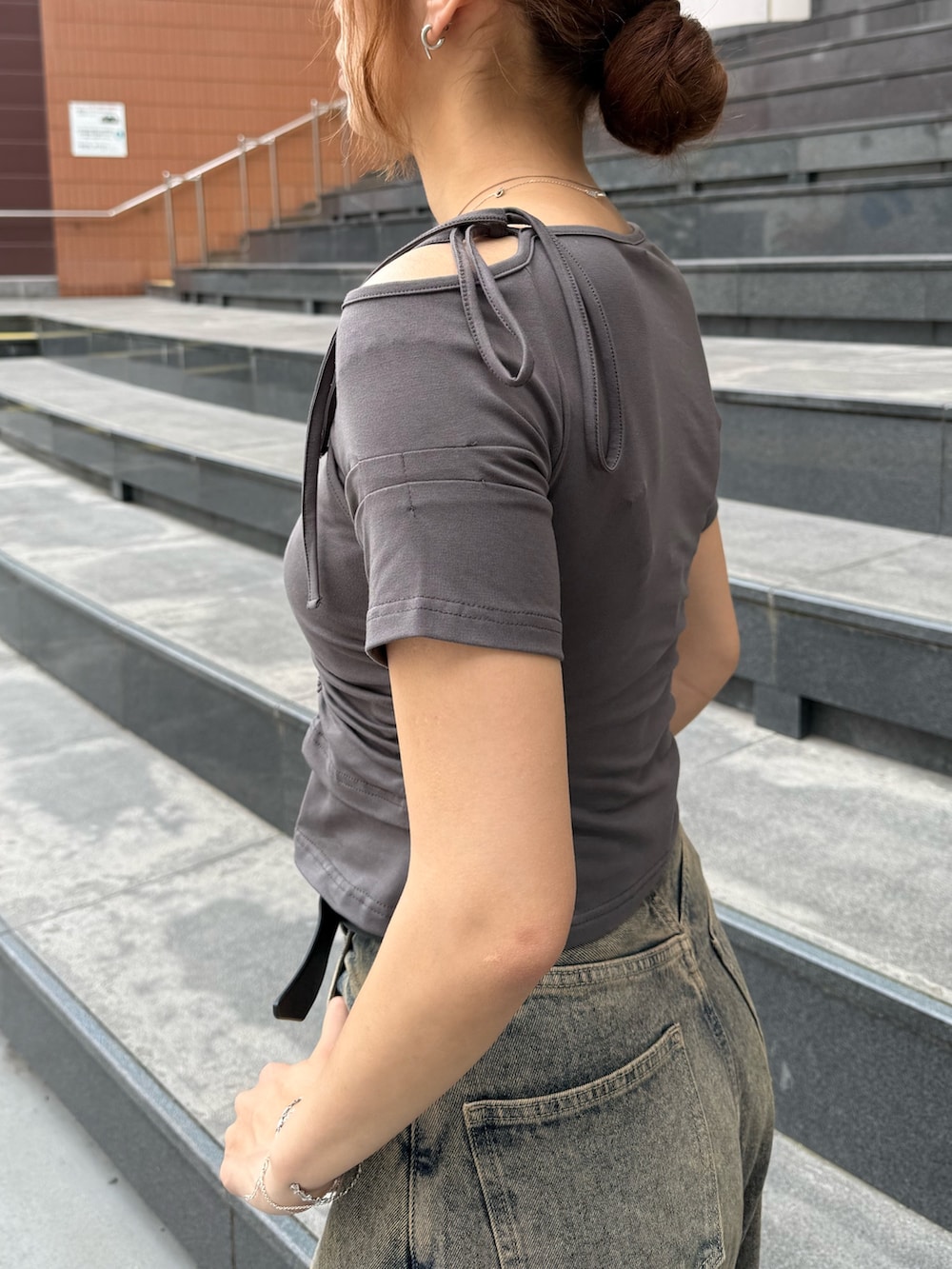 グレー系のTシャツ/カットソー、ブルー系のデニムパンツ、ブラック系のショルダーバッグを着用したレディースの春コーディネートの5枚目の写真