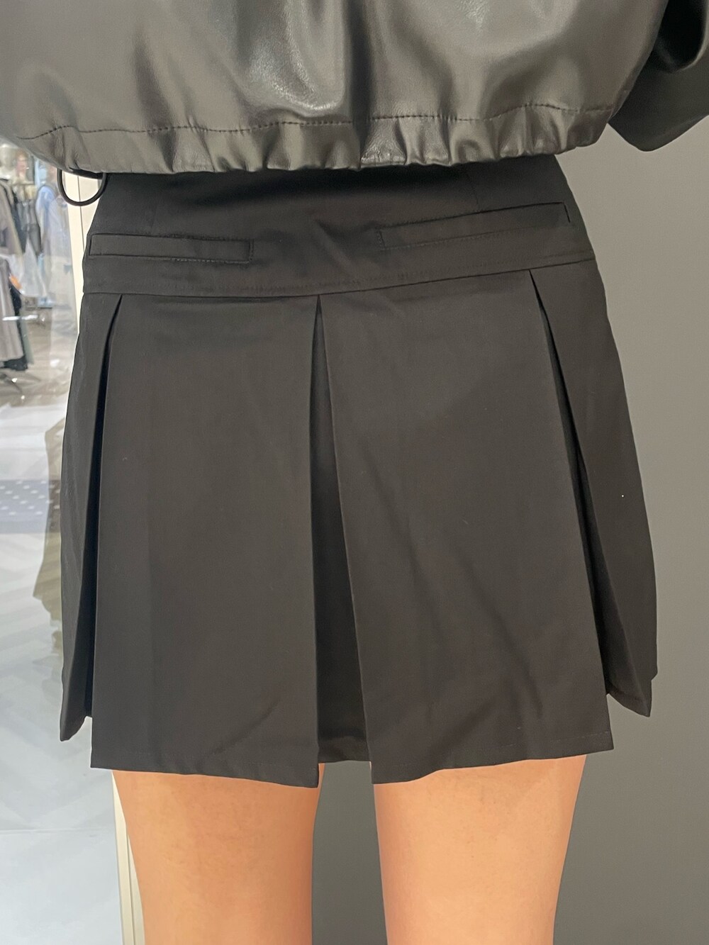 ホワイト系のタンクトップ、ブラック系のブルゾン、ブラック系のスカートを着用したレディースの春コーディネートの9枚目の写真