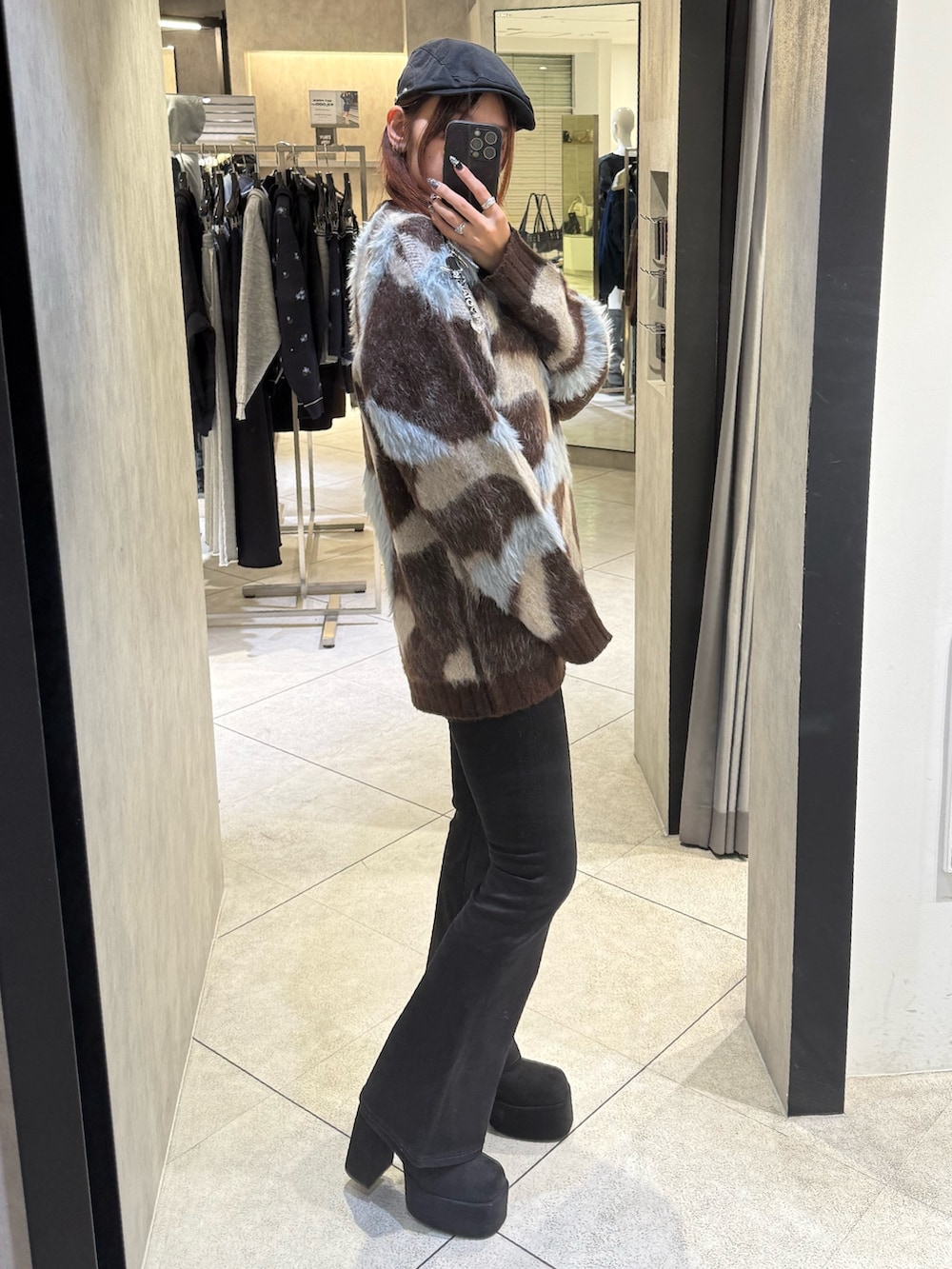 ブラウン系のニット/セーター、ブラック系のデニムパンツ、ブラック系のブーツを着用したレディースの秋コーディネートの2枚目の写真