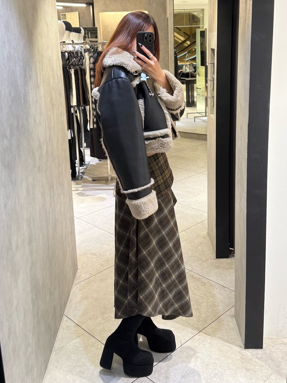 ブラック系のブーツ、グリーン系のスカート、その他のブルゾンを着用したレディースの秋コーディネートの2枚目の写真