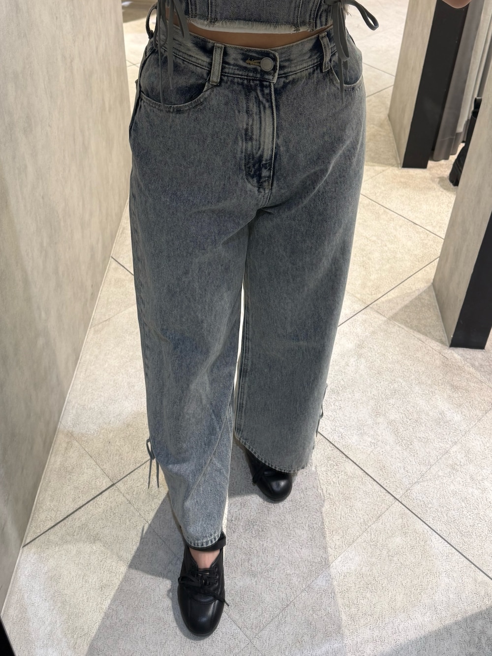 グレー系のTシャツ/カットソー、ブルー系のデニムパンツ、ブラック系のスニーカーを着用したレディースの春コーディネートの6枚目の写真