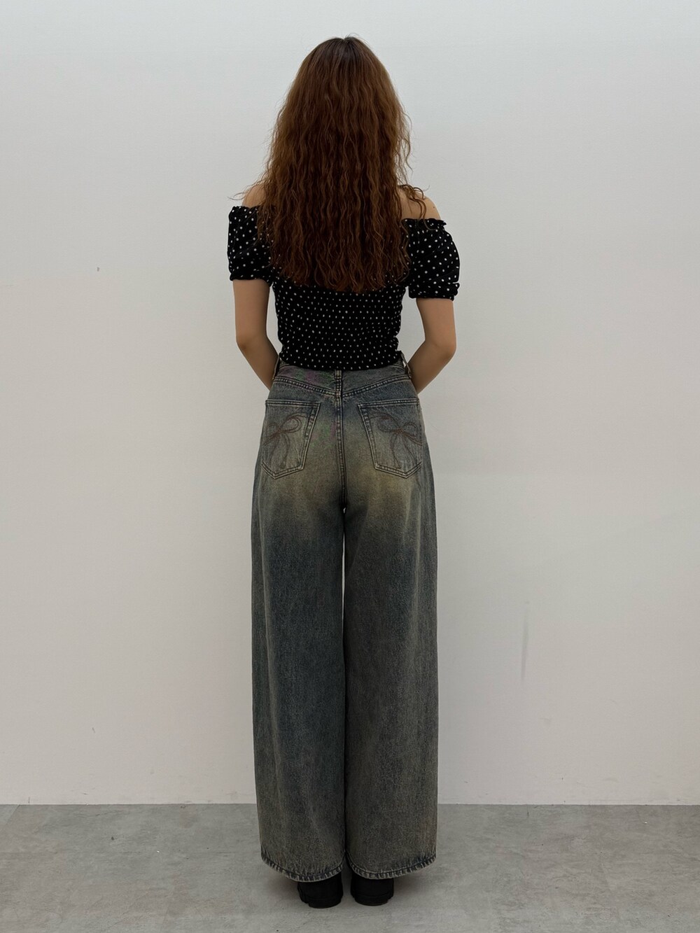 ブラック系のTシャツ/カットソー、ブルー系のデニムパンツ、ブラック系のブーツを着用したレディースの夏コーディネートの3枚目の写真