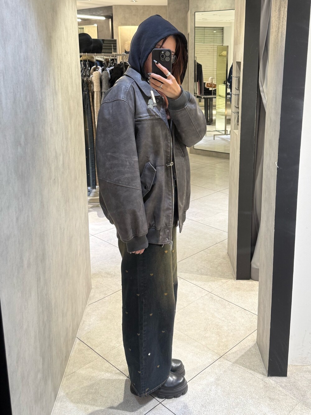 ブラック系のパーカー、グレー系のブルゾン、ブルー系のデニムパンツを着用したレディースの秋コーディネートの2枚目の写真