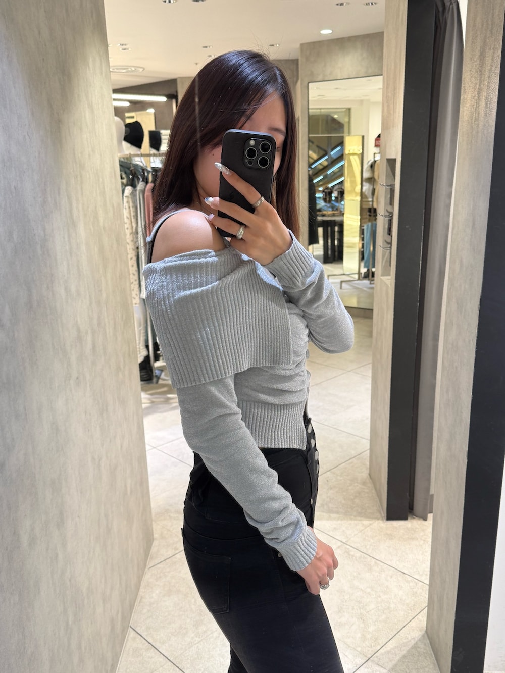 グレー系のニット/セーター、ブラック系のデニムパンツ、ブラック系のブーツを着用したレディースの春コーディネートの5枚目の写真