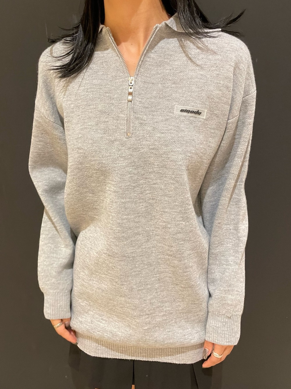 グレー系のワンピース、ブラック系のハンドバッグ、ブラック系のスカートを着用したレディースの秋コーディネートの4枚目の写真