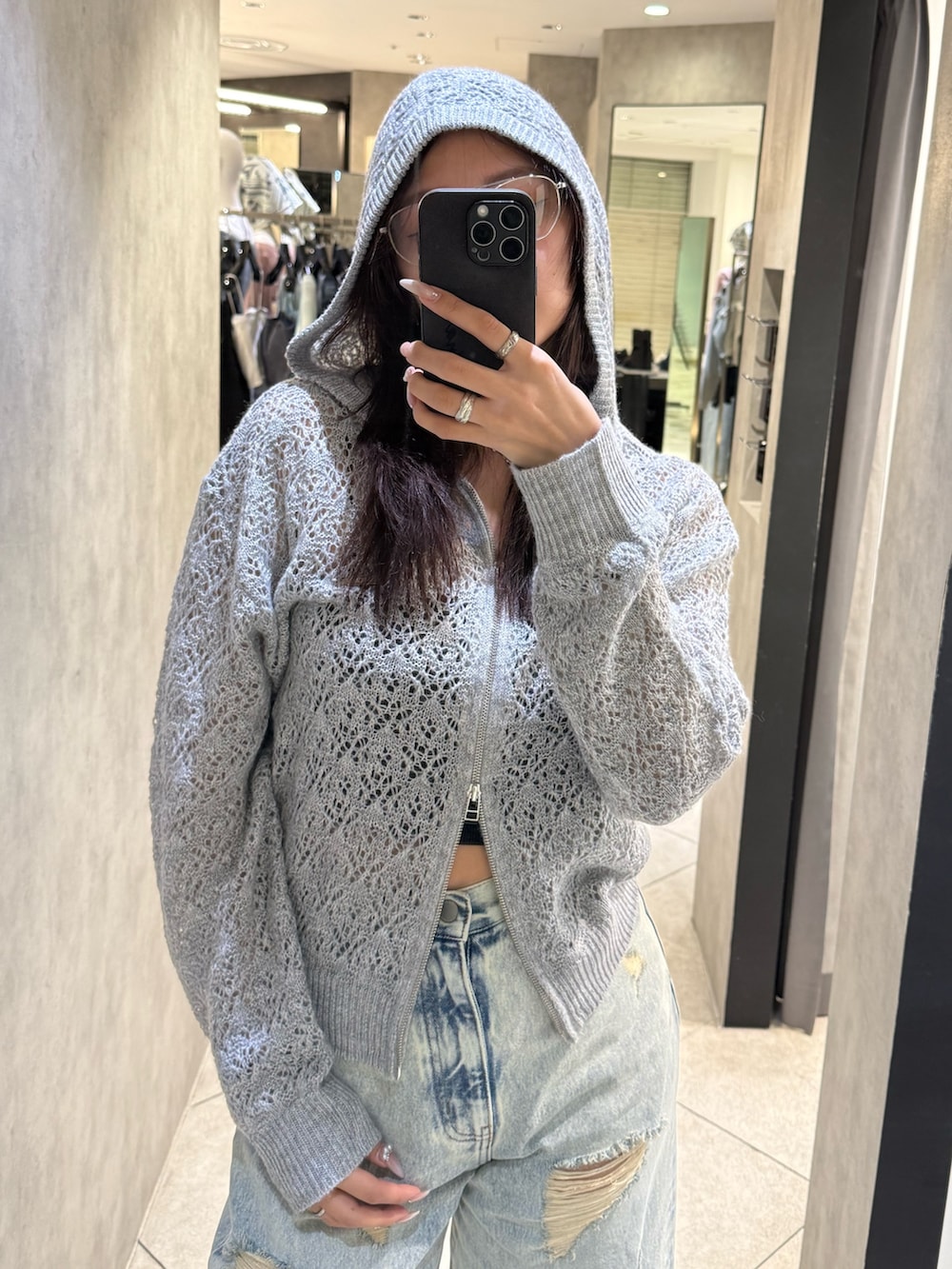 ブラック系のスニーカー、ブルー系のデニムパンツ、グレー系のパーカーを着用したレディースの春コーディネートの4枚目の写真