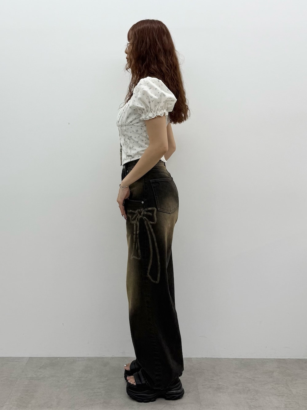 ブラック系のデニムパンツ、ブラック系のサンダル、シルバー系のネックレスを着用したレディースの夏コーディネートの2枚目の写真