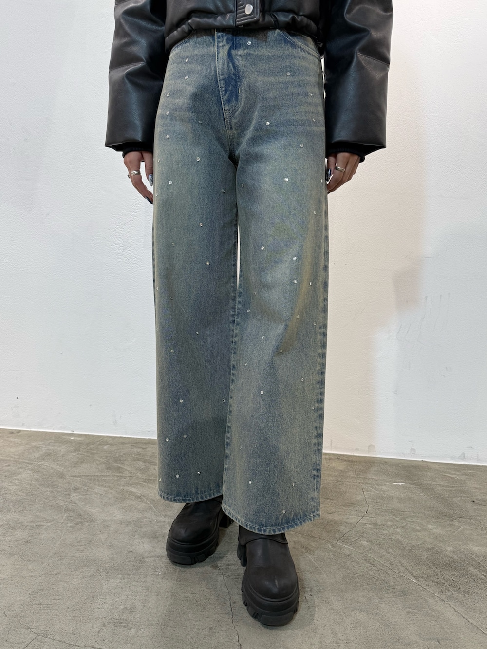 ブラック系のブルゾン、ブルー系のデニムパンツ、ブラック系のブーツを着用したレディースの冬コーディネートの5枚目の写真