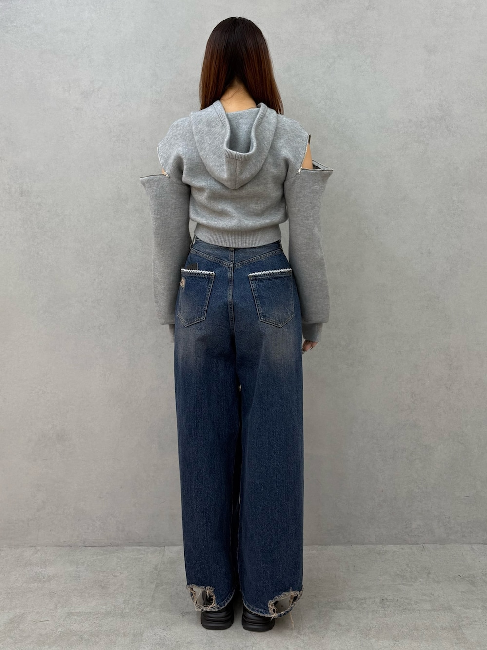 グレー系のパーカー、ブルー系のデニムパンツ、ブラック系のローファーを着用したレディースの冬コーディネートの3枚目の写真