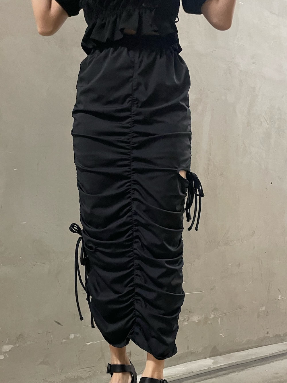 ブラック系のTシャツ/カットソー、ブラック系のスカート、ブラック系のサンダルを着用したレディースの春コーディネートの7枚目の写真