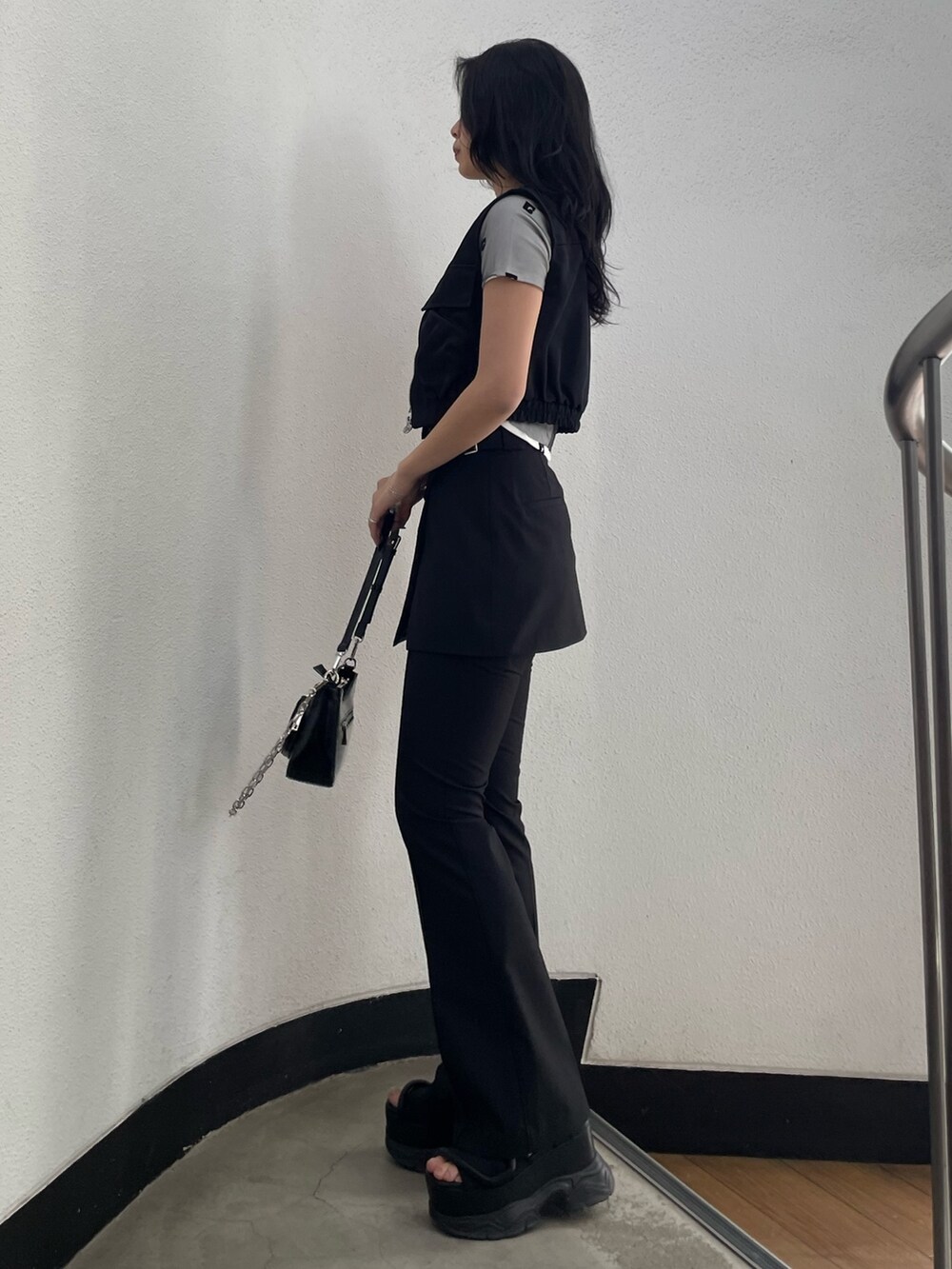 ホワイト系のTシャツ/カットソー、ブラック系のベスト、ブラック系のその他パンツを着用したレディースの春コーディネートの2枚目の写真