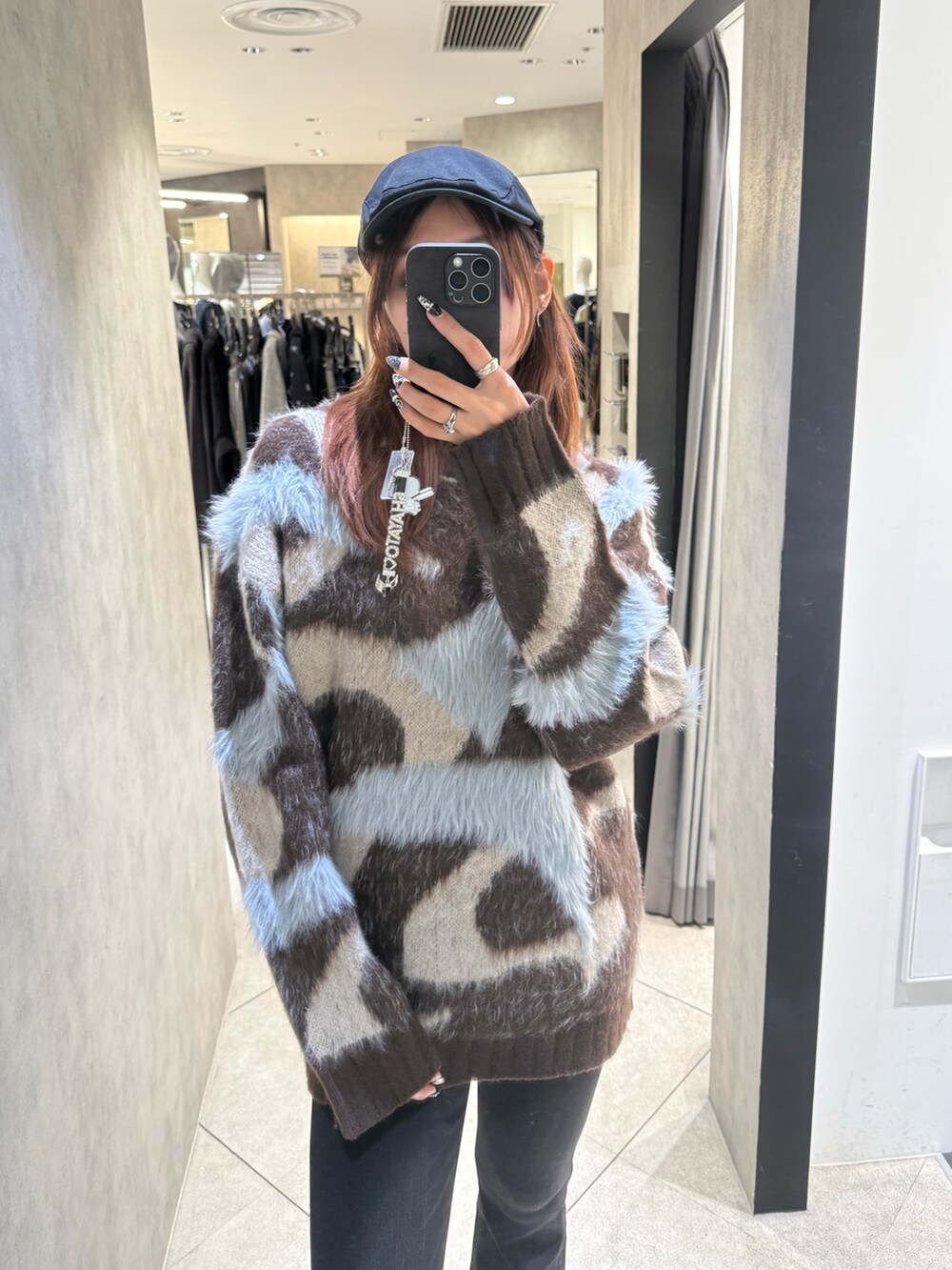 ブラウン系のニット/セーター、ブラック系のデニムパンツ、ブラック系のブーツを着用したレディースの秋コーディネートの4枚目の写真