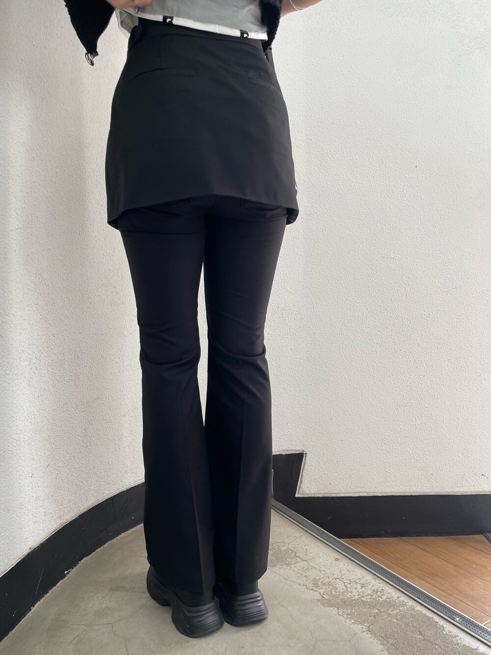 ホワイト系のTシャツ/カットソー、ブラック系のベスト、ブラック系のその他パンツを着用したレディースの春コーディネートの9枚目の写真