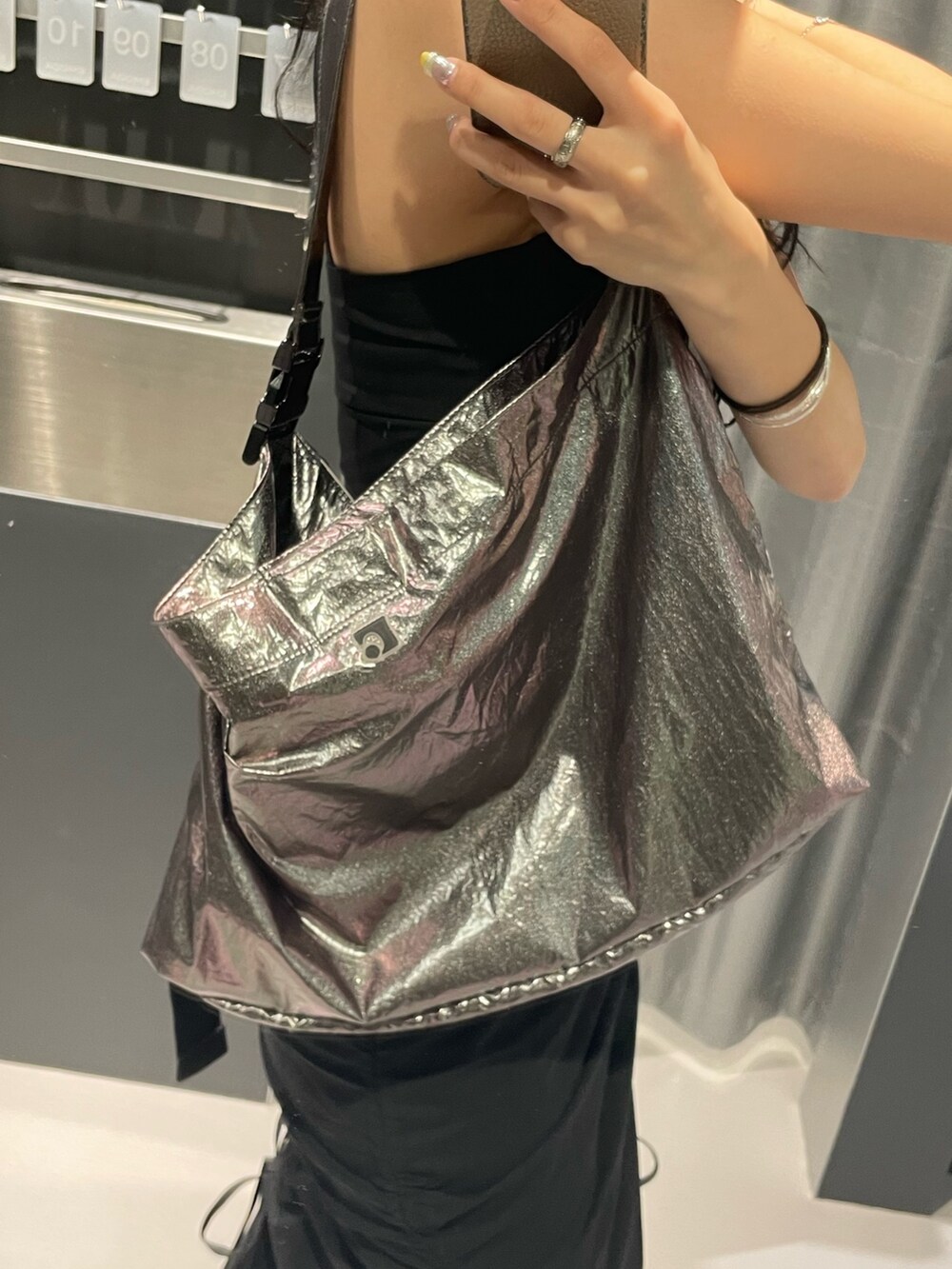 ブラック系のワンピース、グレー系のハンドバッグ、ブラック系のサンダルを着用したレディースの春コーディネートの8枚目の写真