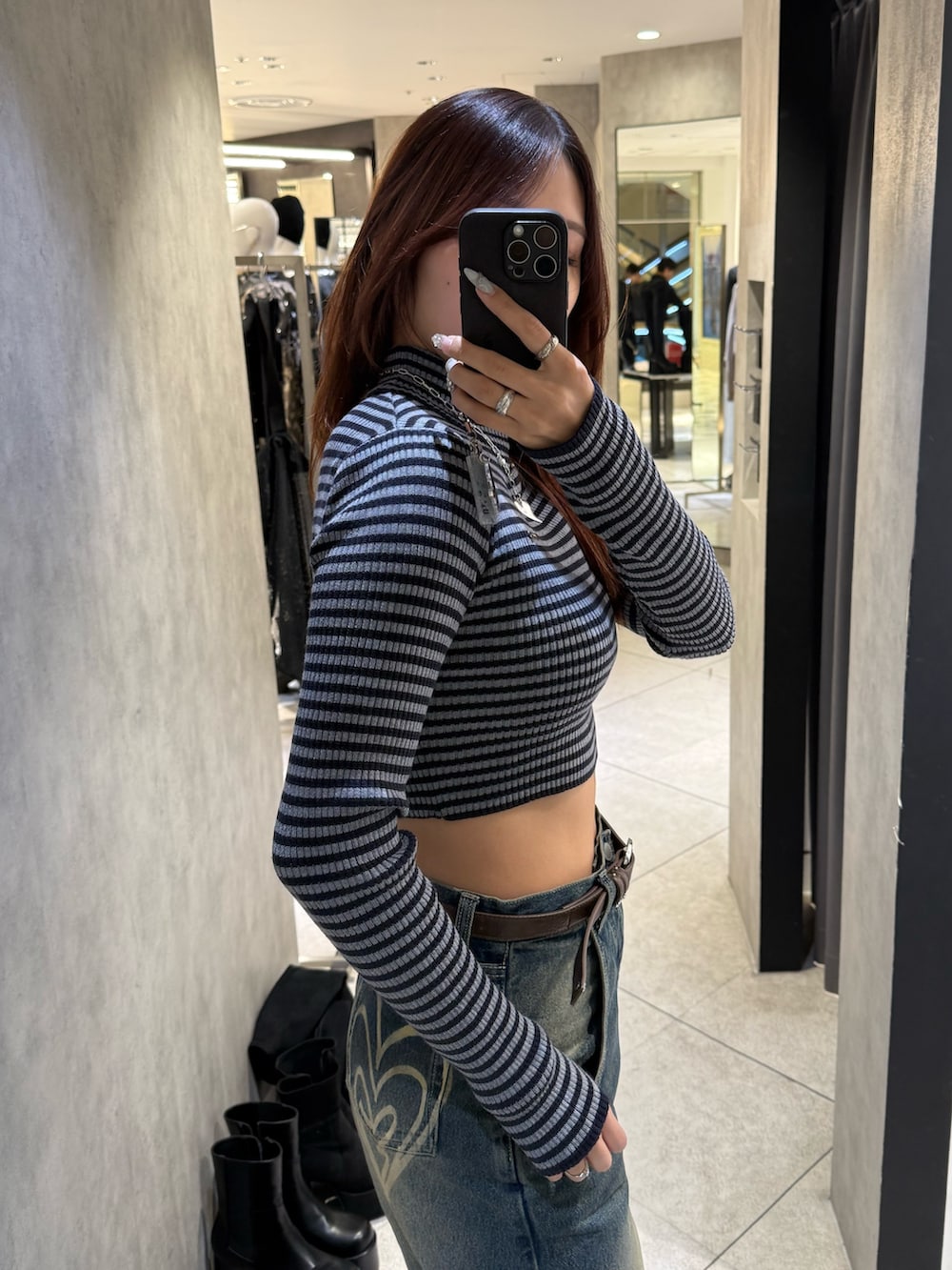 ブルー系のニット/セーター、ブルー系のデニムパンツ、ブラック系のブーツを着用したレディースの冬コーディネートの5枚目の写真