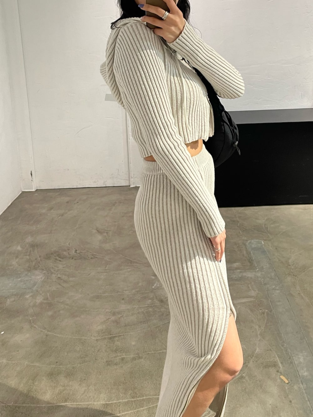 ホワイト系のワンピース、ブラック系のキャミソール、ブラック系のブーツを着用したレディースの春コーディネートの6枚目の写真