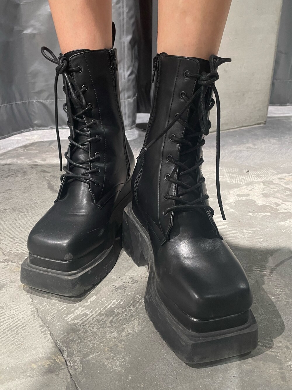 ブルー系のニット/セーター、ブラック系のデニムパンツ、ブラック系のブーツを着用したレディースの春コーディネートの10枚目の写真