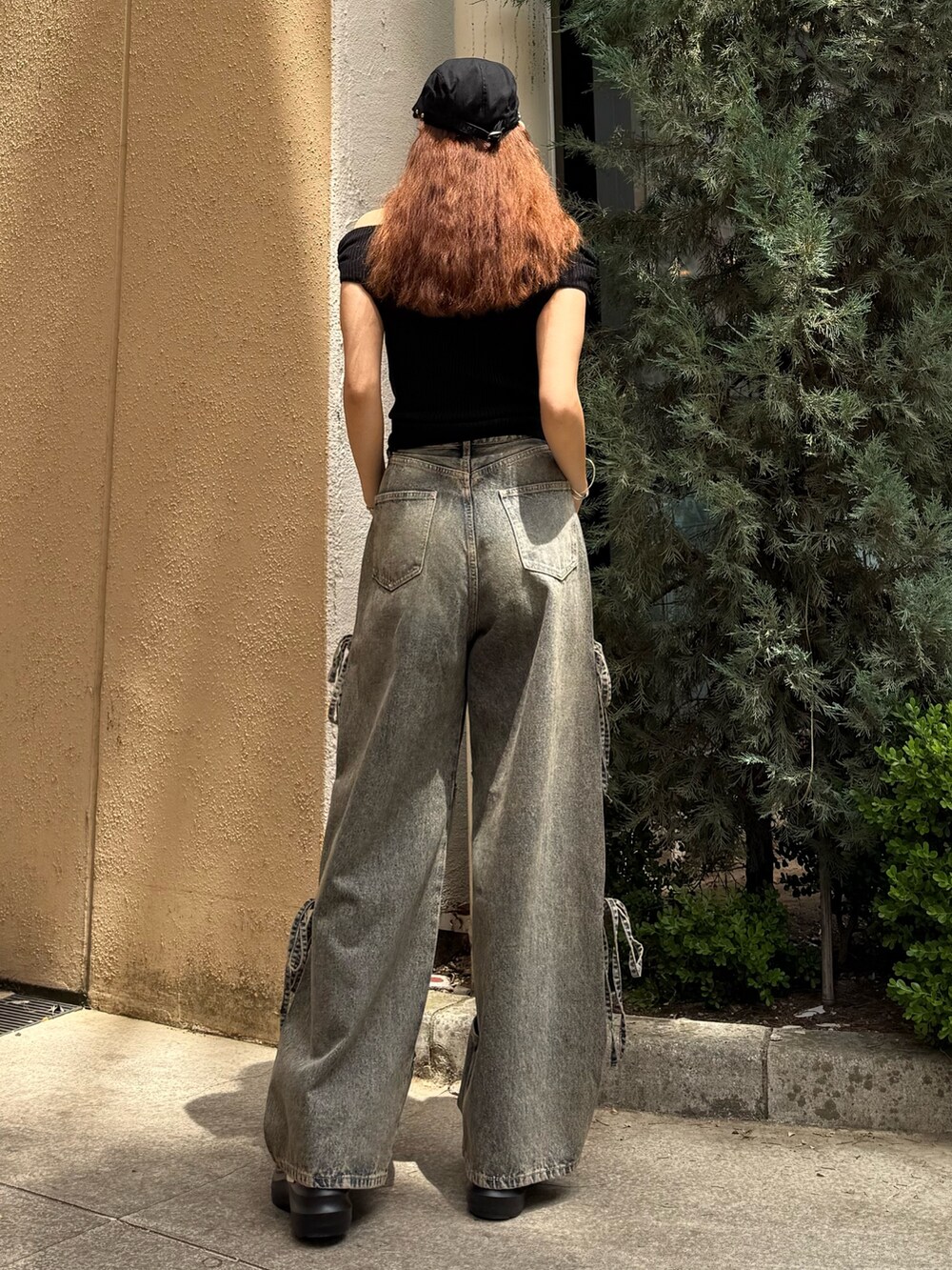 ブラック系のニット/セーター、ブルー系のデニムパンツ、ブラック系のサンダルを着用したレディースの夏コーディネートの3枚目の写真