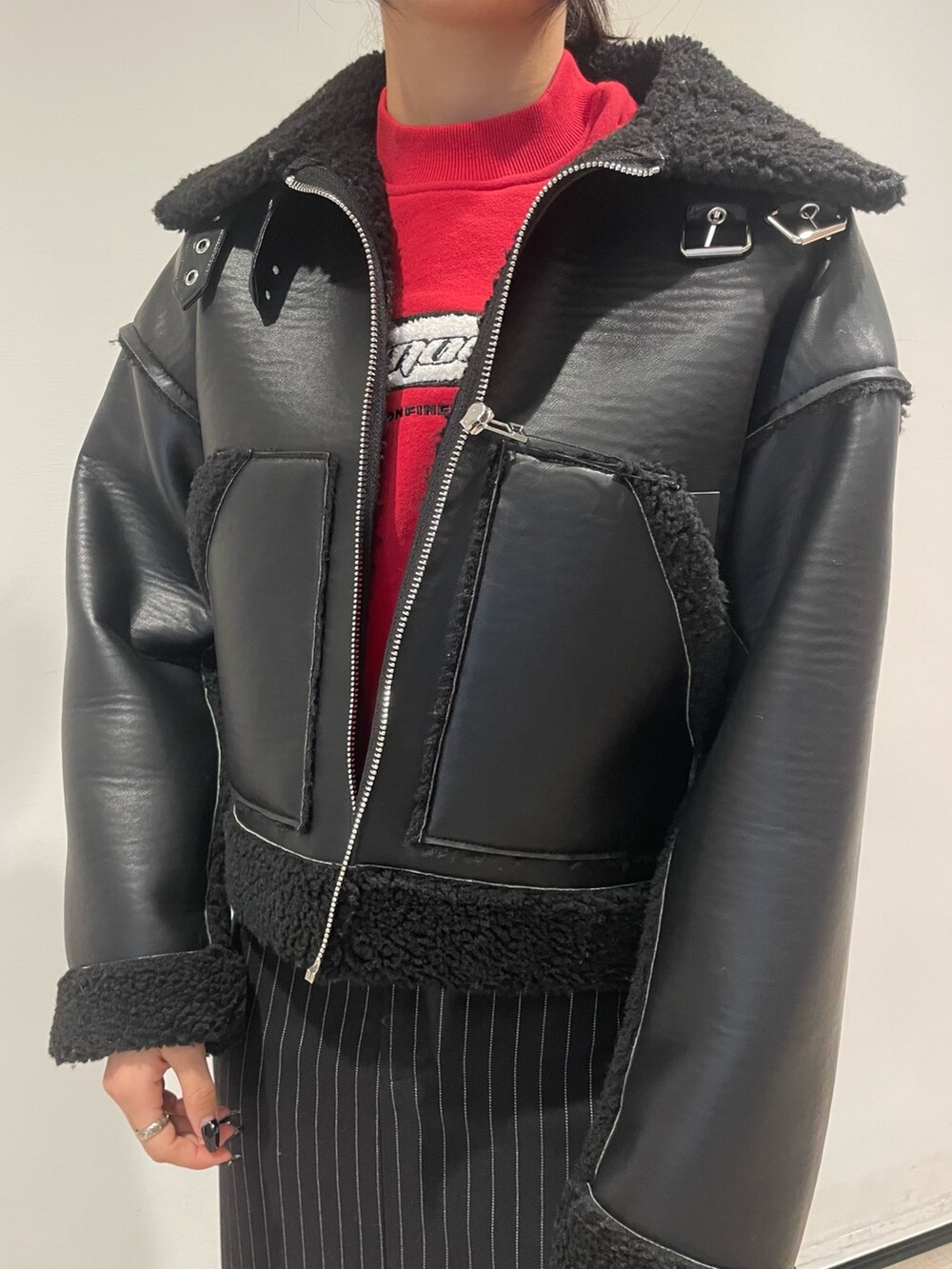 レッド系のスウェット、ブラック系のブルゾン、ブラック系のハンドバッグを着用したレディースの冬コーディネートの4枚目の写真