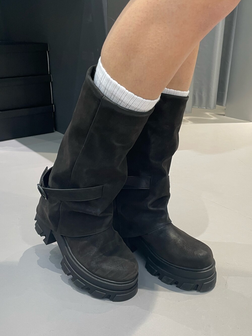 ブラック系のニット/セーター、ブラック系のワンピース、ブラック系のブーツを着用したレディースの冬コーディネートの9枚目の写真